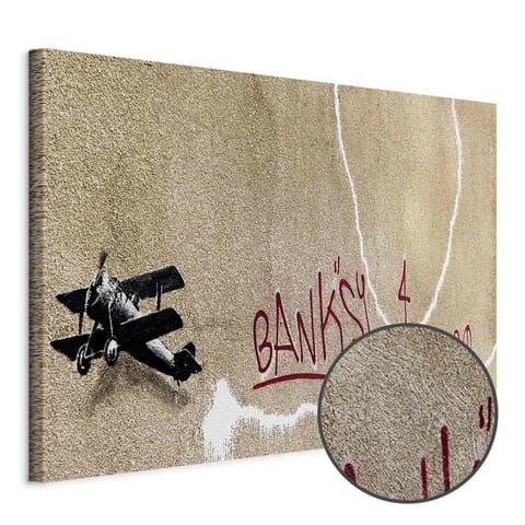 ⁨Obraz - Samolot Banksy (1-częściowy) - graffiti czerwone napisy na tle muralu (rozmiar 90x60, wykończenie Premium Print)⁩ w sklepie Wasserman.eu