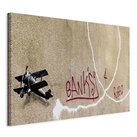 ⁨Obraz - Samolot Banksy (1-częściowy) - graffiti czerwone napisy na tle muralu (rozmiar 30x20, wykończenie Standard)⁩ w sklepie Wasserman.eu