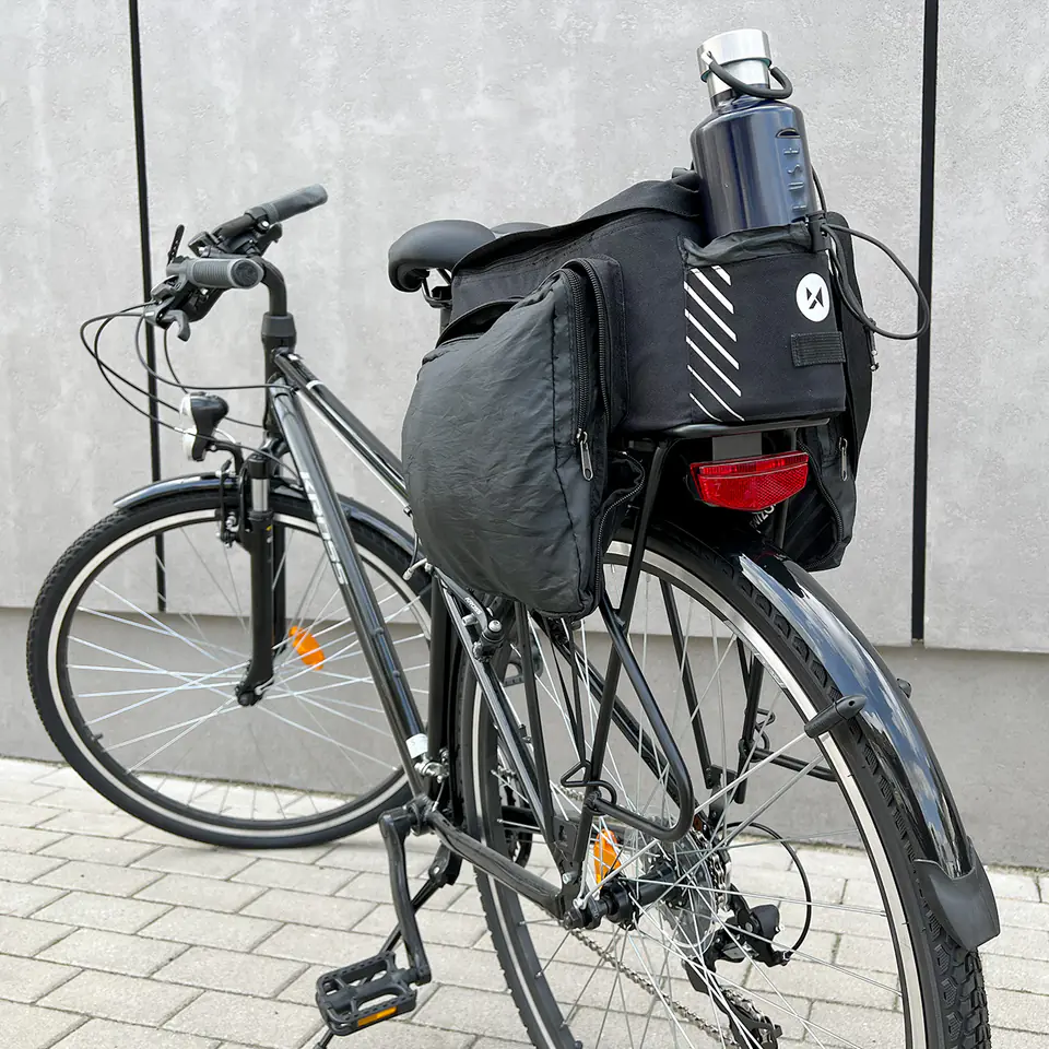 Torba rowerowa na bagażnik z paskiem Wozinsky WBB22BK z rozłożoną kieszenią i zamocowanym bidonem