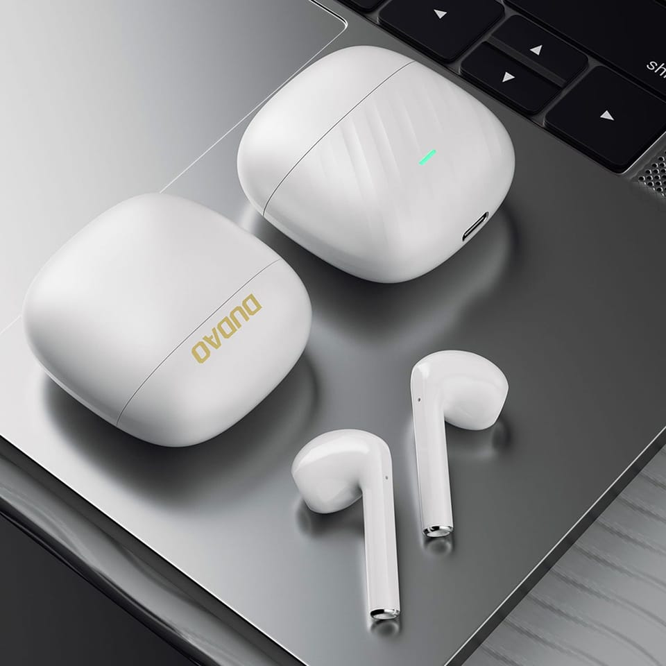 MacBook Pro na których leżą słuchawki bezprzewodowe Dudao U14+ TWS wraz z etui