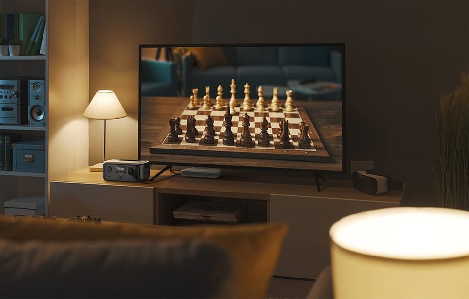 Stacja EcoFlow RIVER 3 podłączona do telewizora w salonie, na ekranie plansza do gry w szachy