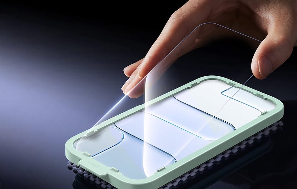 Dłoń montująca szkło hartowane na telefonie za pomocą ramki instalacyjnej, pokazująca prosty i precyzyjny montaż