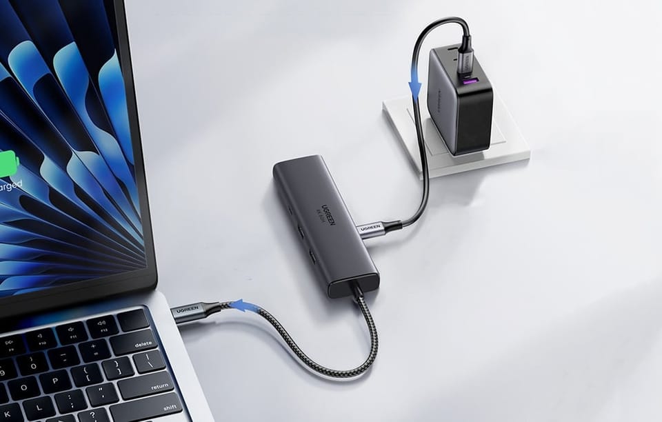 Adapter Ugreen CM512 w szarym kolorze na jasnoniebieskim tle.