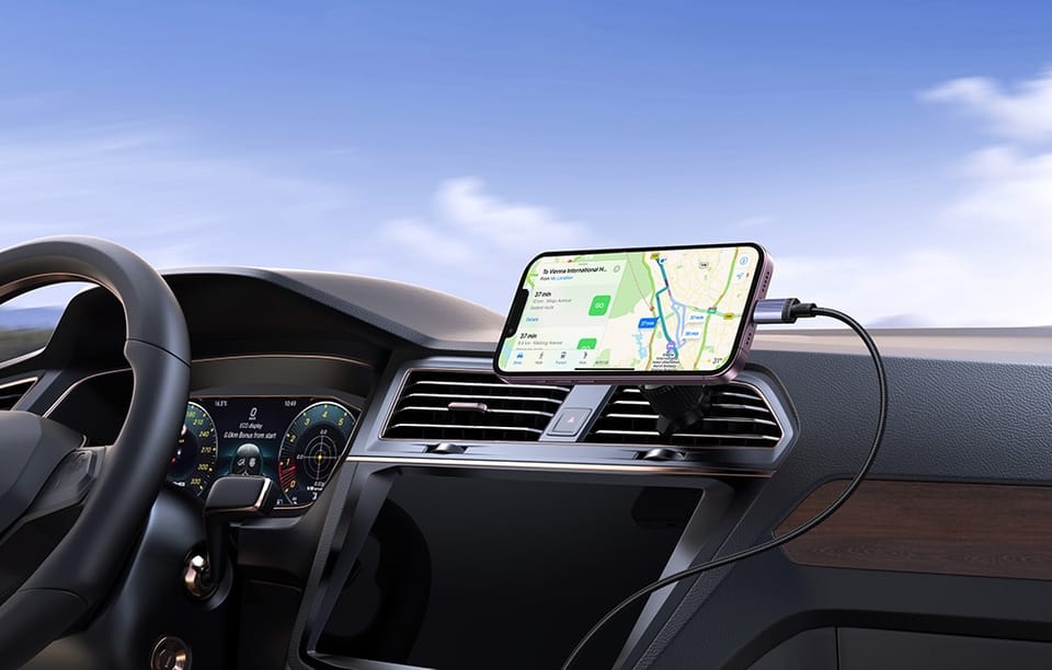 iPhone z mapą nawigacyjną zamocowany na desce rozdzielczej samochodu z kablem do ładowania