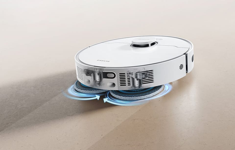 Robot sprzątający z dwoma wirującymi padami mopującymi czyści jasną podłogę.