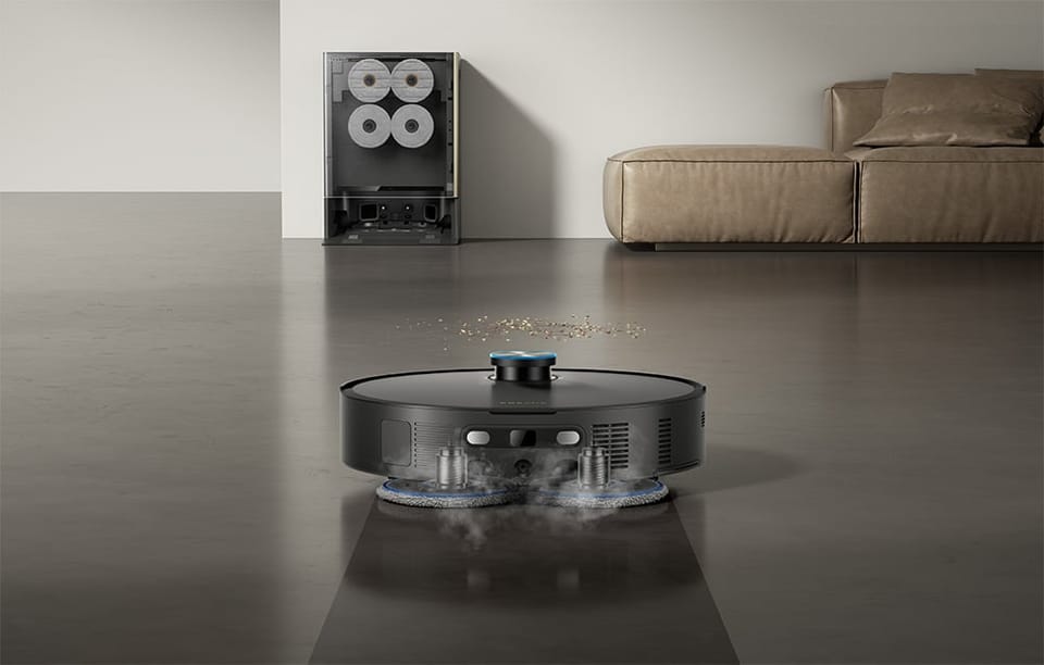 Zbliżenie na pady mopujące robota Dreame Matrix10 Ultra, w tle widać kanapę i stację dokującą.
