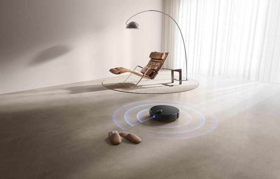 Robot sprzątający odkurza podłogę i omija przeszkody.
