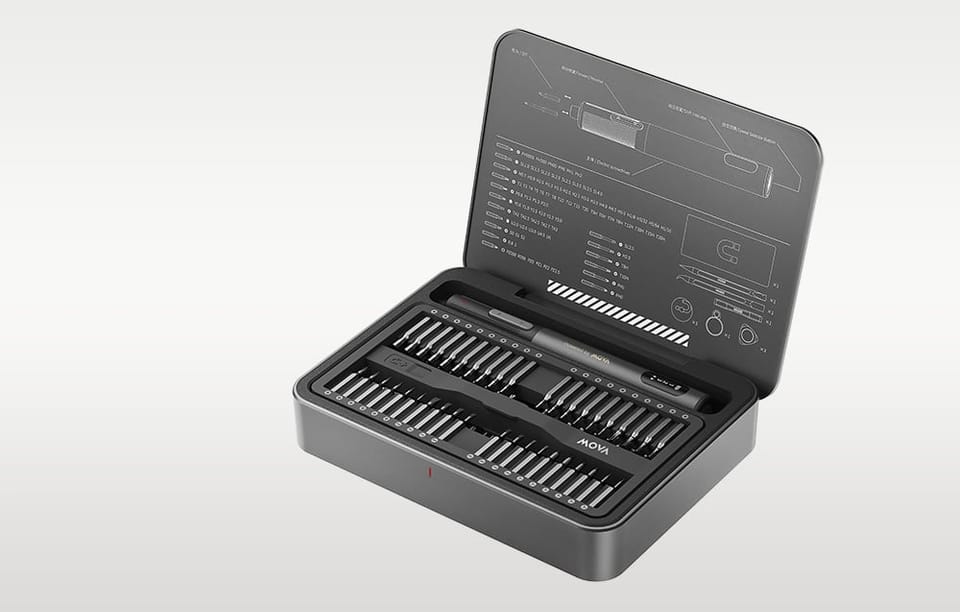 Otwarte etui z wkrętakiem elektrycznym i bitami na szarym tle