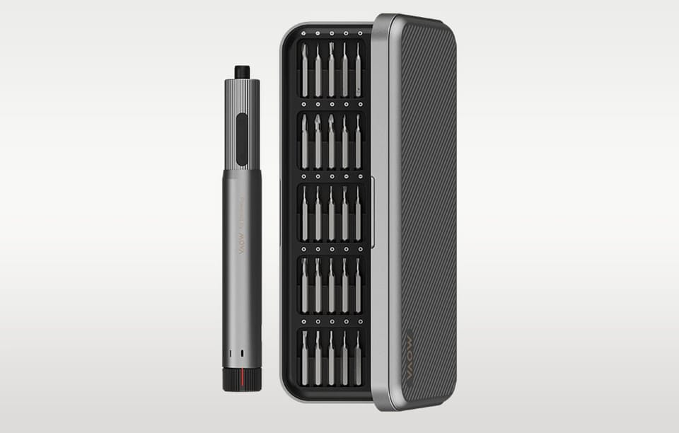 Wkrętak elektryczny obok półotwartego etui z bitami na szarym tle