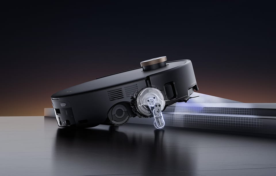 Czarny robot sprzątający wjeżdża na próg.