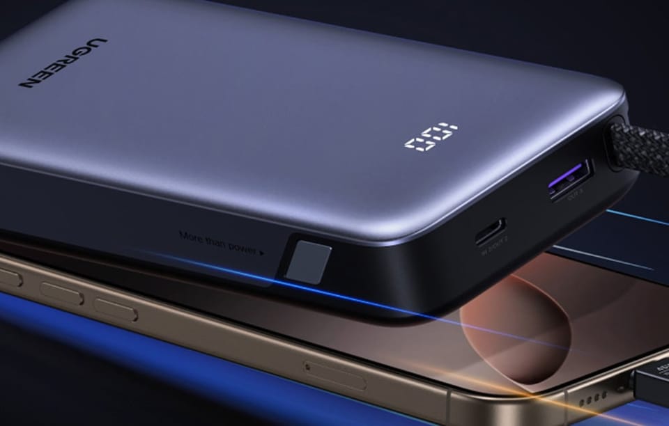 Szary powerbank Ugreen i smartfon leżą obok siebie.