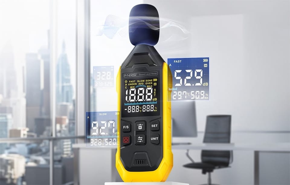 Miernik poziomu dźwięku z osłoną mikrofonu i wyświetlaczem pokazującym pomiar w biurze z widokiem na miasto.