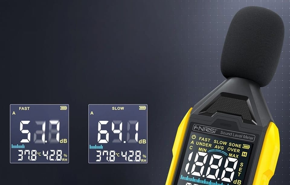 Zbliżenie na miernik poziomu dźwięku z osłoną mikrofonu oraz dwoma ekranami porównawczymi pokazującymi wyniki w decybelach.