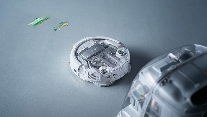 obot sprzątający ROMO zbiera zabrudzenia z podłogi, obok znajduje się stacja dokująca