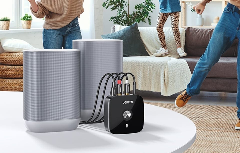 Adapter Bluetooth UGREEN podłączony do głośników w jasnym salonie z rodziną w tle