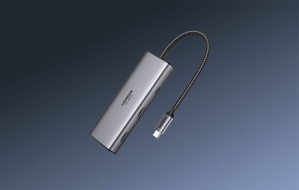 Adapter Ugreen CM498 w szarym kolorze na ciemnym tle.