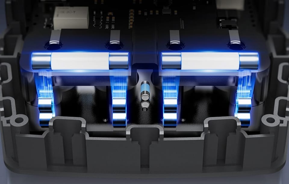 Wnętrze obudowy z bezpiecznikami podświetlonymi na niebiesko i widocznymi połączeniami elektrycznymi.