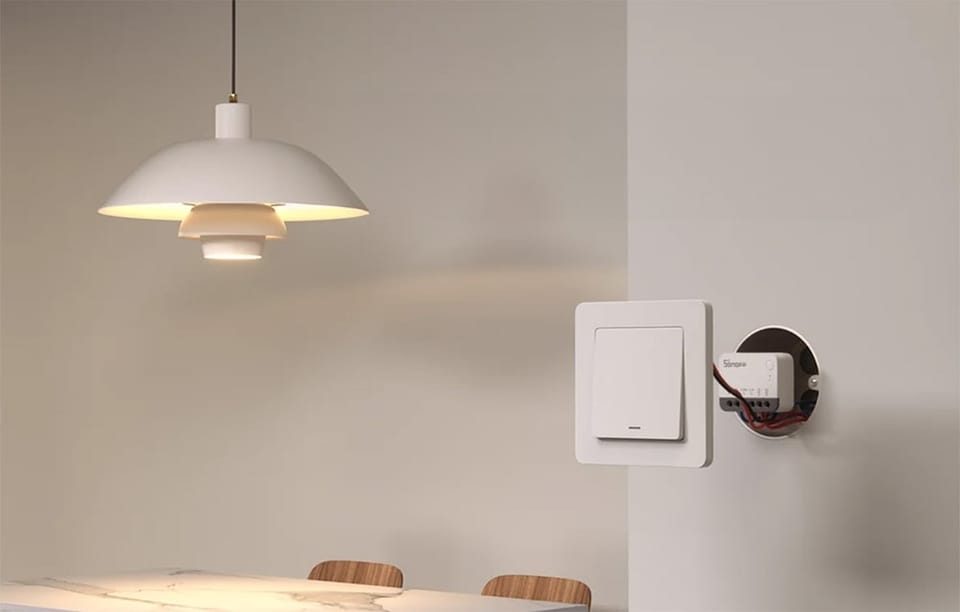 Moduł Sonoff zainstalowany w puszce podtynkowej obok włącznika światła przy ścianie w jadalni