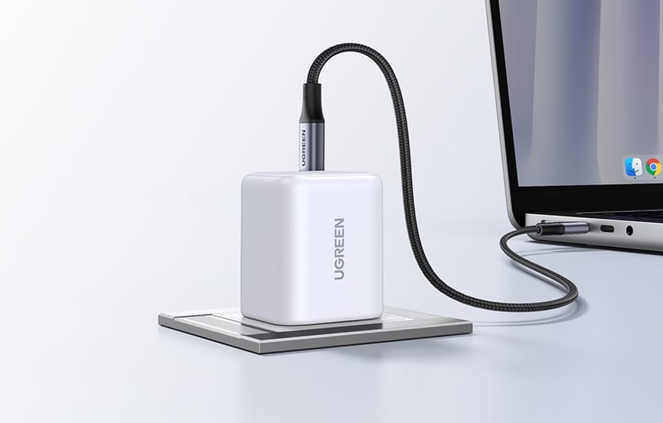 Biała ładowarka sieciowa w gniazdu z podłączonym szarym kablem 