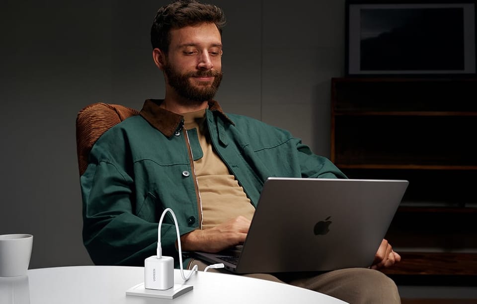 Mężczyzna z laptopem podłączonym do ładowarki Ugreen 