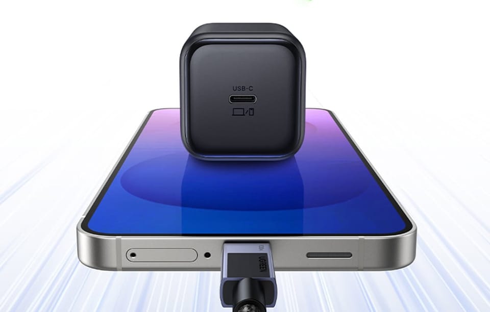 Czarna ładowarka UGREEN z portem USB-C ustawiona na smartfonie z podłączonym kablem USB-C.