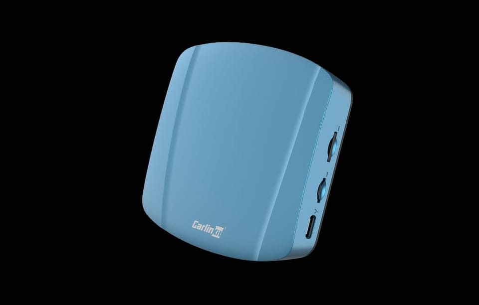 Adapter bezprzewodowy Carlinkit TBOX ULTRA w kolorze niebieskim, widziany pod skosem, na czarnym tle.
