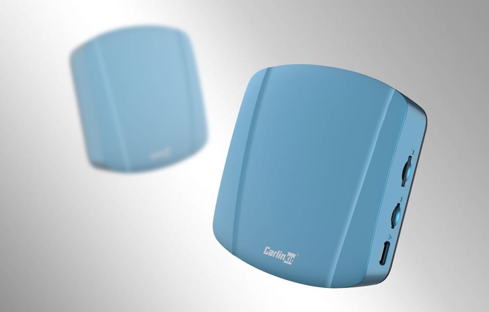 Dwa adaptery bezprzewodowe Carlinkit TBOX ULTRA, na jasnym tle, jeden rozmyty.