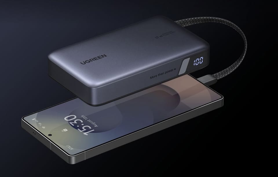 Zbliżenie na powerbank Ugreen 67W ładujący smartfon. Na boku urządzenia widoczny jasny wyświetlacz stanu baterii.