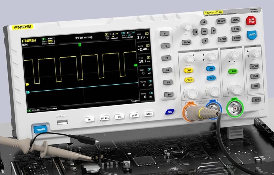 Oscyloskop z podłączonymi sondami mierzącymi sygnał na płycie elektronicznej, na ekranie widoczny wykres prostokątny.