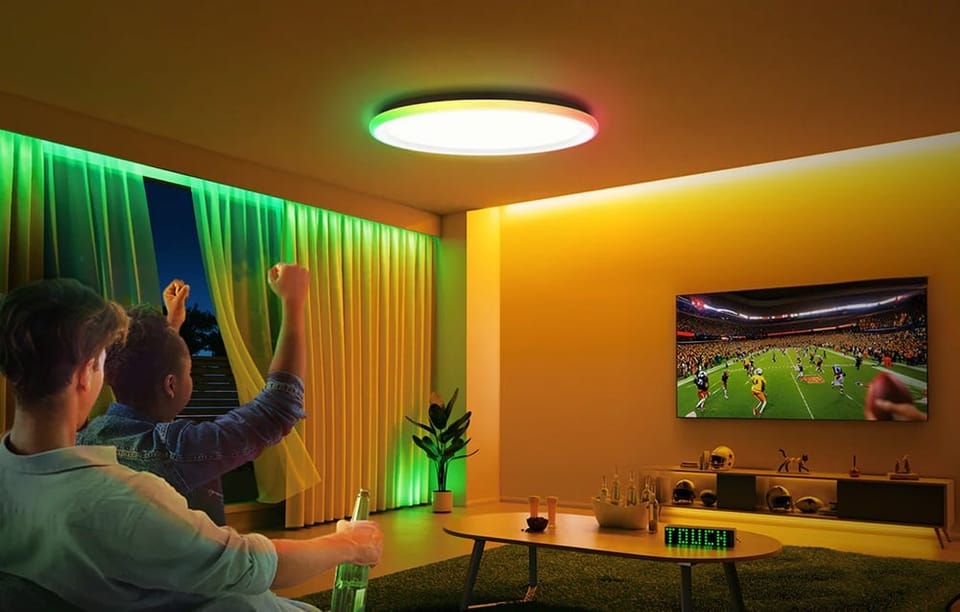 Dwóch mężczyzn oglądających mecz w salonie oświetlonym lampą Yeelight Mars C300 w kolorze zielonym i żółtym.