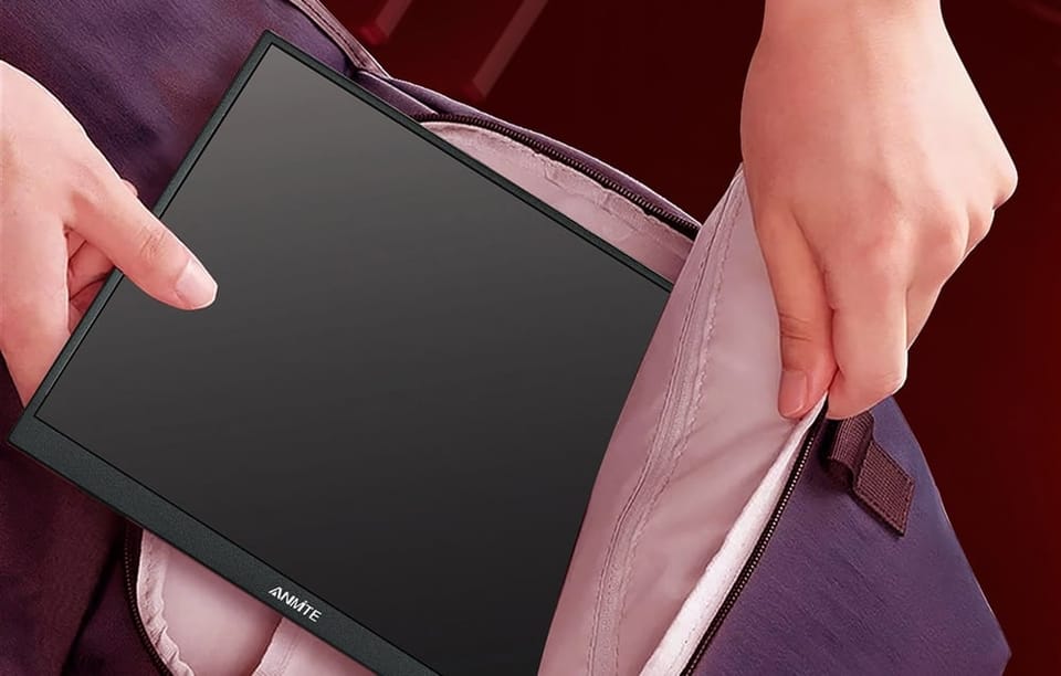 Dłonie wkładające smukły monitor przenośny do otwartego plecaka.
