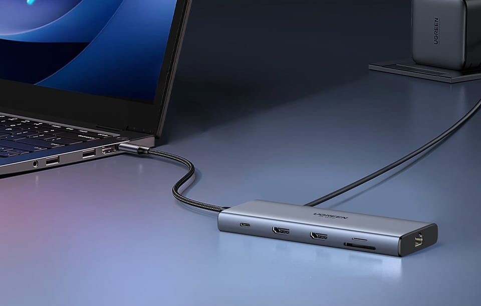 Hub Ugreen podłączony do laptopa przez kabel z widocznymi portami