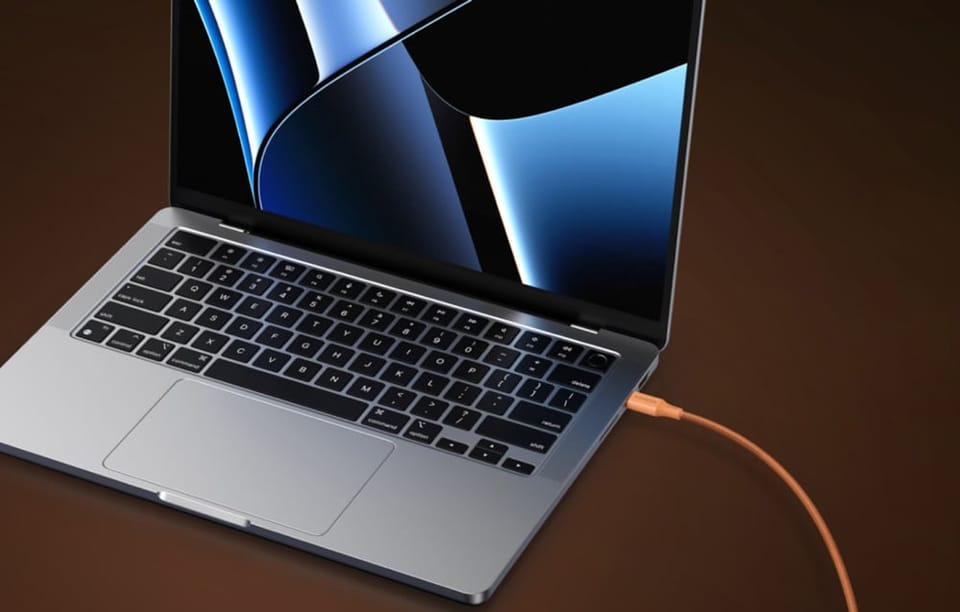 Laptop podłączony do pomarańczowego kabla UGREEN.