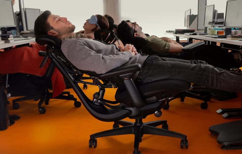 Mężczyźni i kobieta w biurze siedzą na mocno odchylonych fotelach ergonomicznych