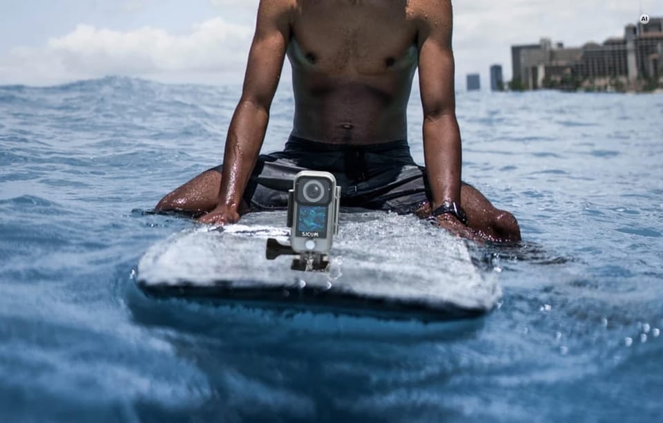 Surfer na desce z zamontowaną z przodu wodoodporną kamerą SJCAM.